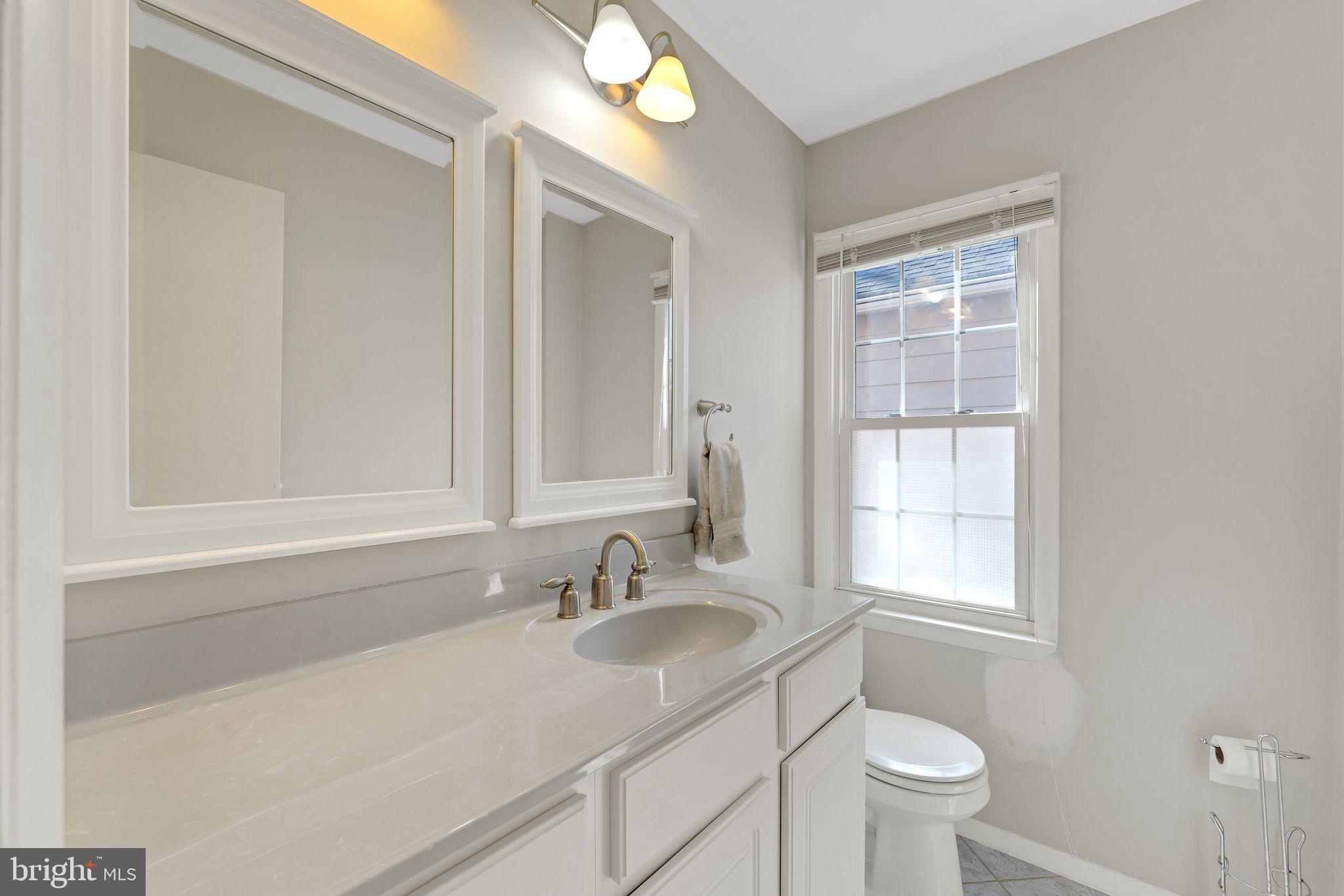 1436 Jerrold Place Crofton, MD 21114 - Photo 12 of 34 a bathroom with a sink a toilet and a window