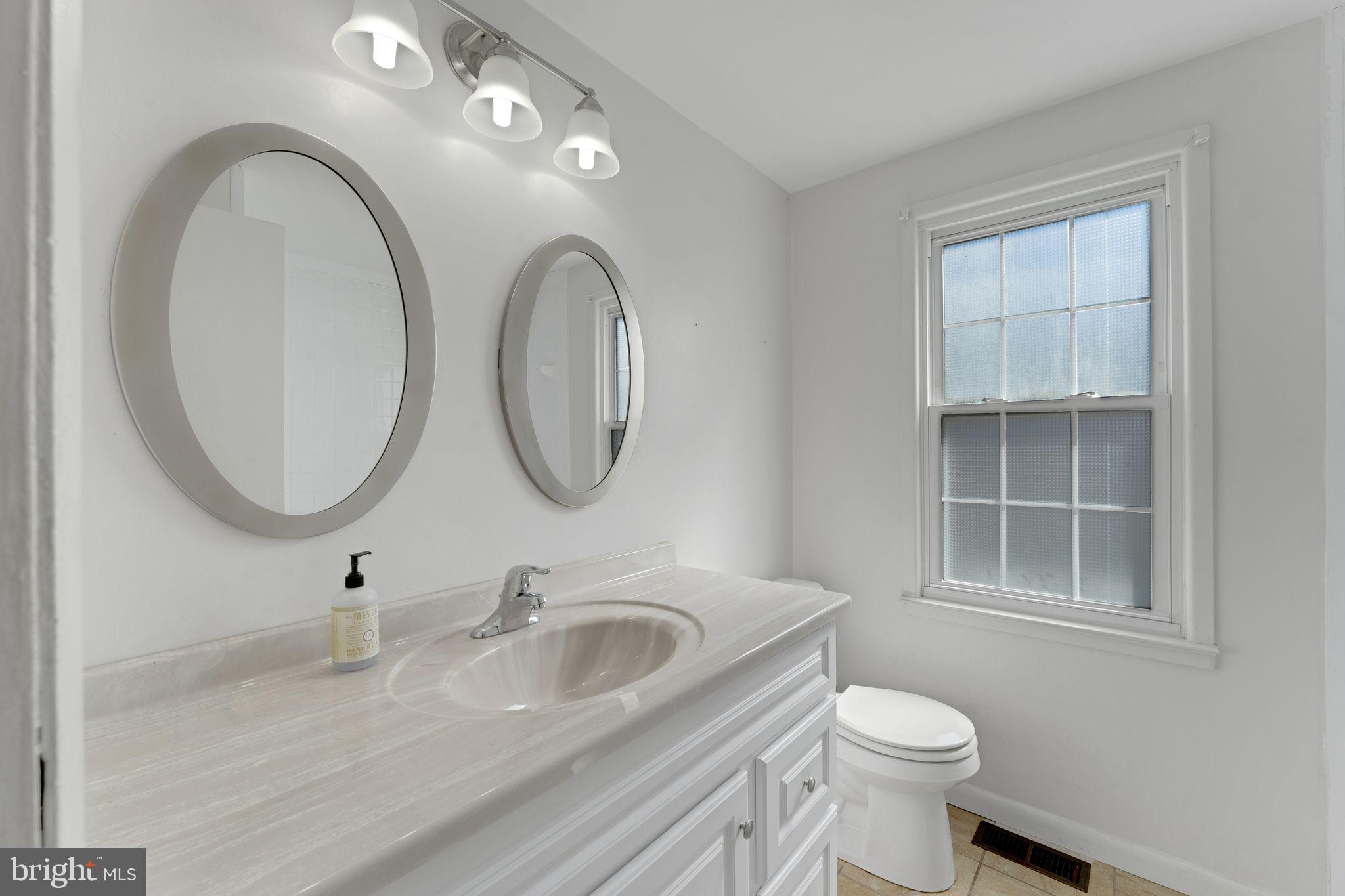 1436 Jerrold Place Crofton, MD 21114 - Photo 13 of 34 a bathroom with a granite countertop toilet a sink and a mirror