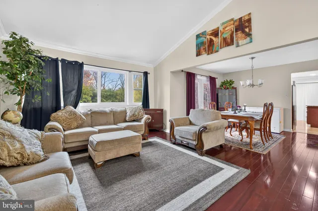 a living room with furniture wooden floor and a large window