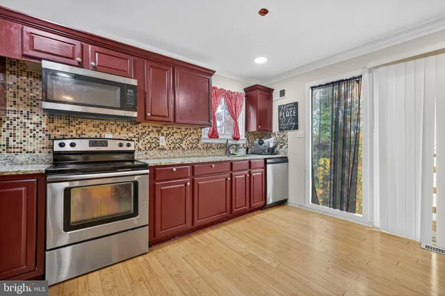 a kitchen with stainless steel appliances kitchen island granite countertop a stove microwave and refrigerator