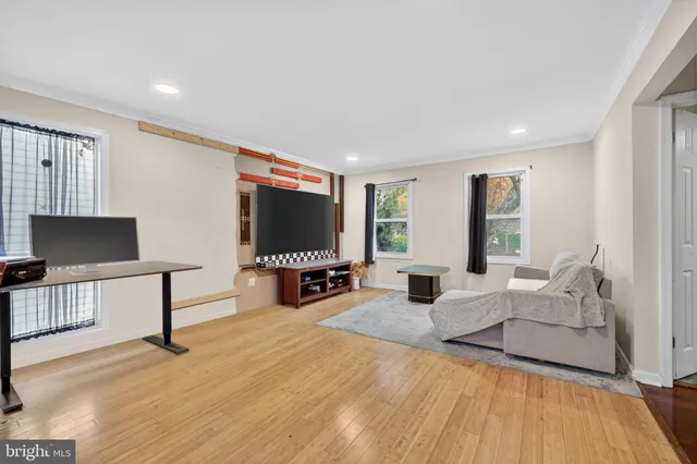 a living room with furniture a flat screen tv and a large window