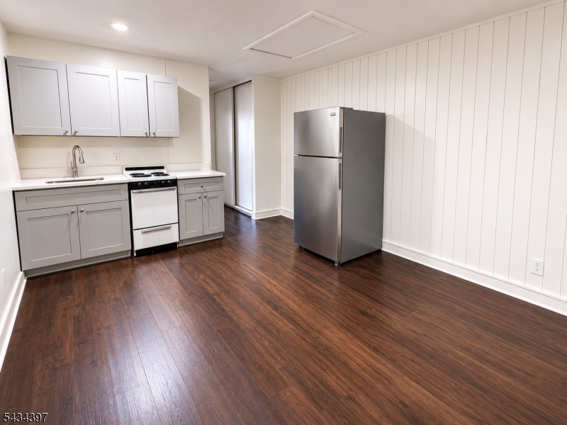 207 Old Chimney Ridge Road, Unit L Montague, NJ 07827 - Photo 4 of 14 a kitchen with wooden floors white cabinets and stainless steel appliances