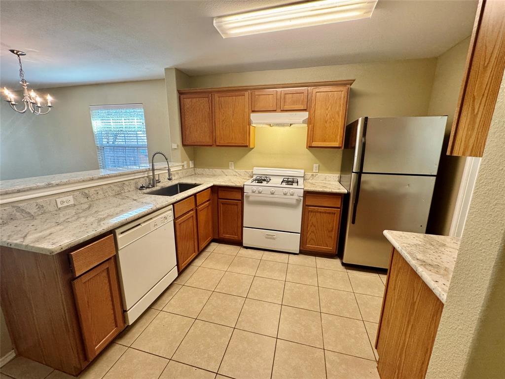 7812 Duber Lane Austin, TX 78747 - Photo 6 of 15 a kitchen with a stove a sink a refrigerator and a counter top space