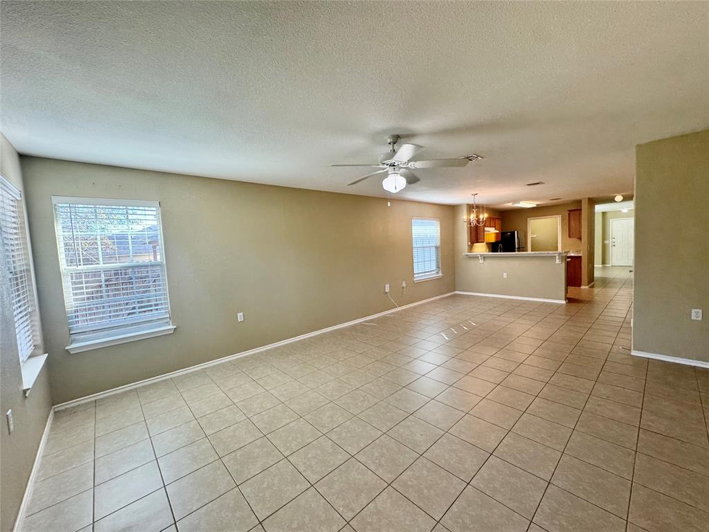 7812 Duber Lane Austin, TX 78747 - Photo 10 of 15 an empty room with windows and chandelier fan