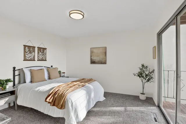 a bedroom with a bed and a potted plant