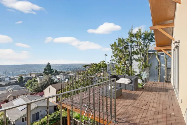 a view of a balcony with two chairs and a potted plant