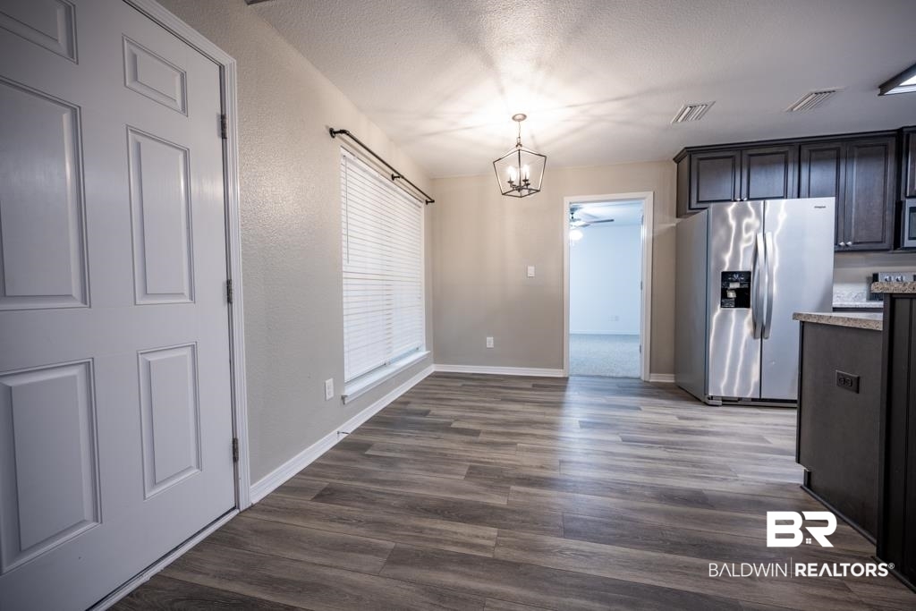15874 Carver Road, Unit C Foley, AL 36535 - Photo 15 of 18 Interior space with dark brown cabinets, dark hardwood / wood-style floors, decorative light fixtures, and stainless steel refrigerator with ice dispenser