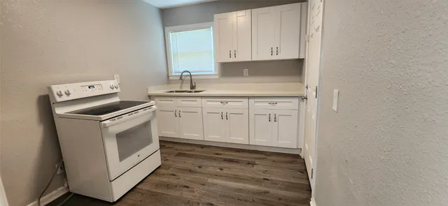 a kitchen with white cabinets and sink