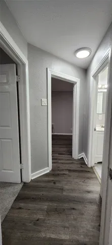 a view of a hallway with wooden floor and a fireplace
