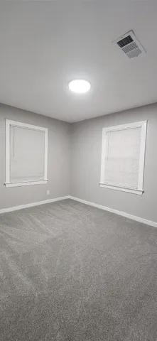 an empty room with windows and closet