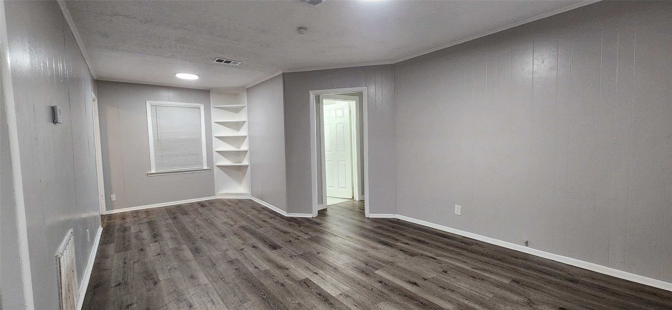 128 Huisache Street Lake Jackson, TX 77566 - Photo 5 of 23 wooden floor in an empty room with a window