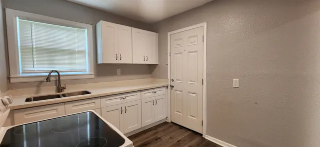 a kitchen with white cabinets and a sink