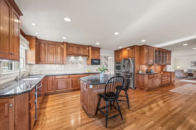 a kitchen with stainless steel appliances granite countertop a kitchen island a table and chairs