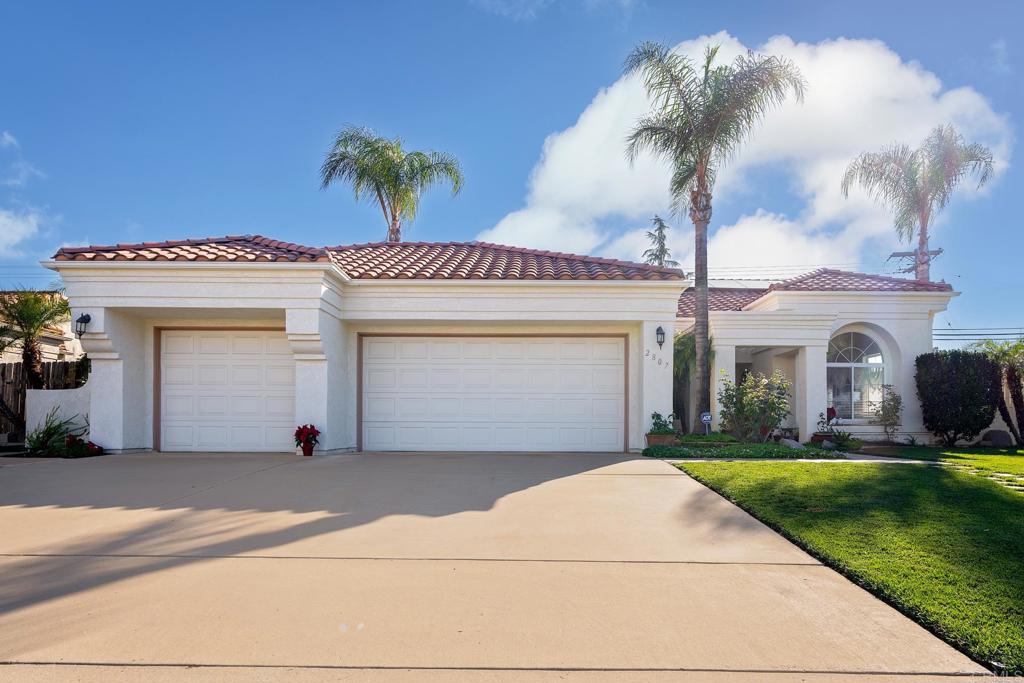 a view of a house with a yard and a garage