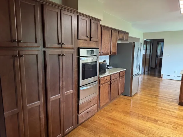 a kitchen with stainless steel appliances granite countertop a refrigerator a stove and a wooden cabinets