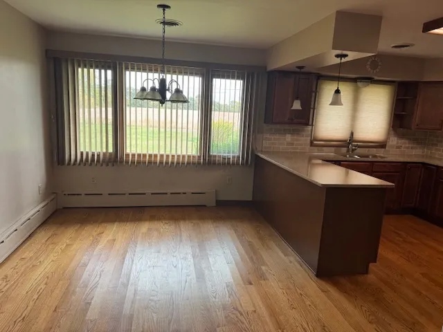 a kitchen with granite countertop wooden floors and a wide window