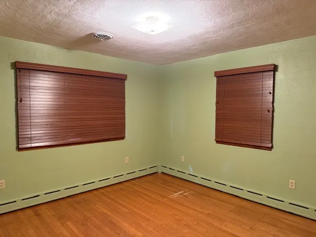 a view of a room with wooden floor and windows