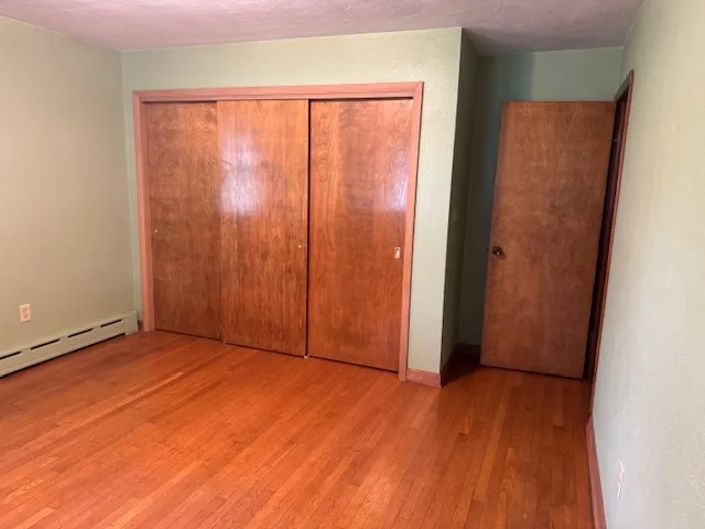 an empty room with wooden floor and sliding door