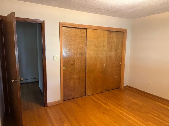 an empty room with wooden floor and a window