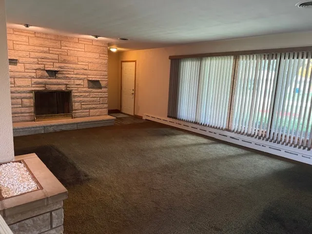 a view of an empty room with a fireplace and a window