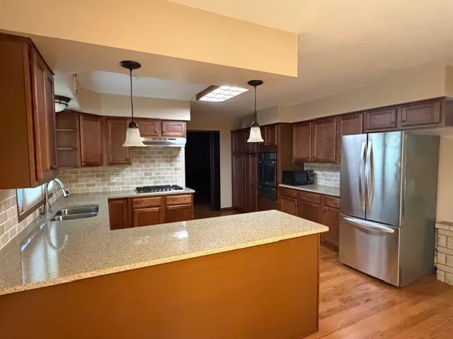 a large kitchen with a large counter top stainless steel appliances and cabinets