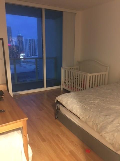1900 North Bayshore Drive, Unit 2609 Miami, FL 33132 - Photo 22 of 36 a bedroom with a bed and wooden floor