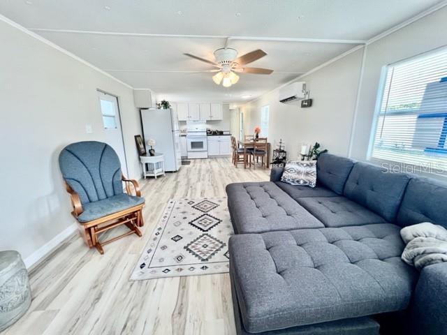 10826 Tioga Drive Port Richey, FL 34668 - Photo 25 of 59 a living room with furniture a large window and a chandelier