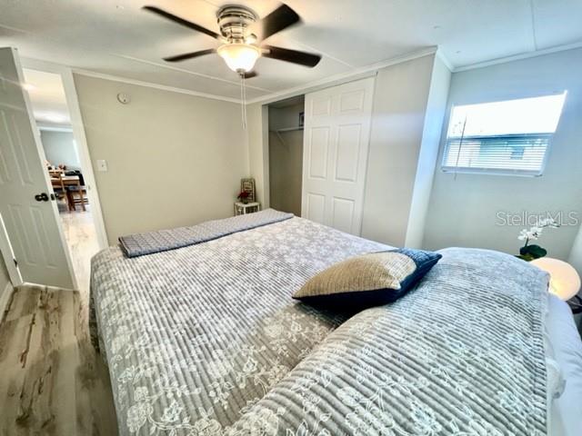 10826 Tioga Drive Port Richey, FL 34668 - Photo 33 of 59 a bedroom with a large bed and a chandelier