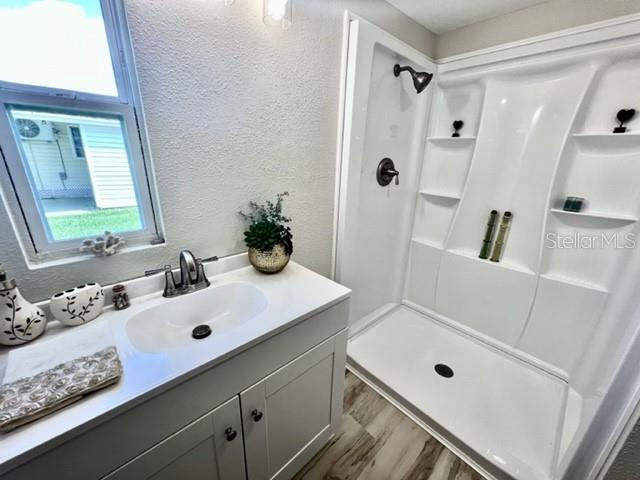 10826 Tioga Drive Port Richey, FL 34668 - Photo 37 of 59 a bathroom with a tub sink a mirror a vanity and shower