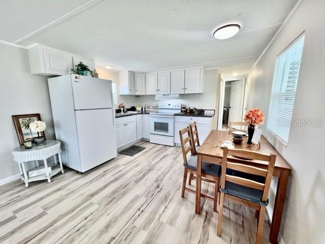 10826 Tioga Drive Port Richey, FL 34668 - Photo 9 of 59 a kitchen with wooden floors and white appliances