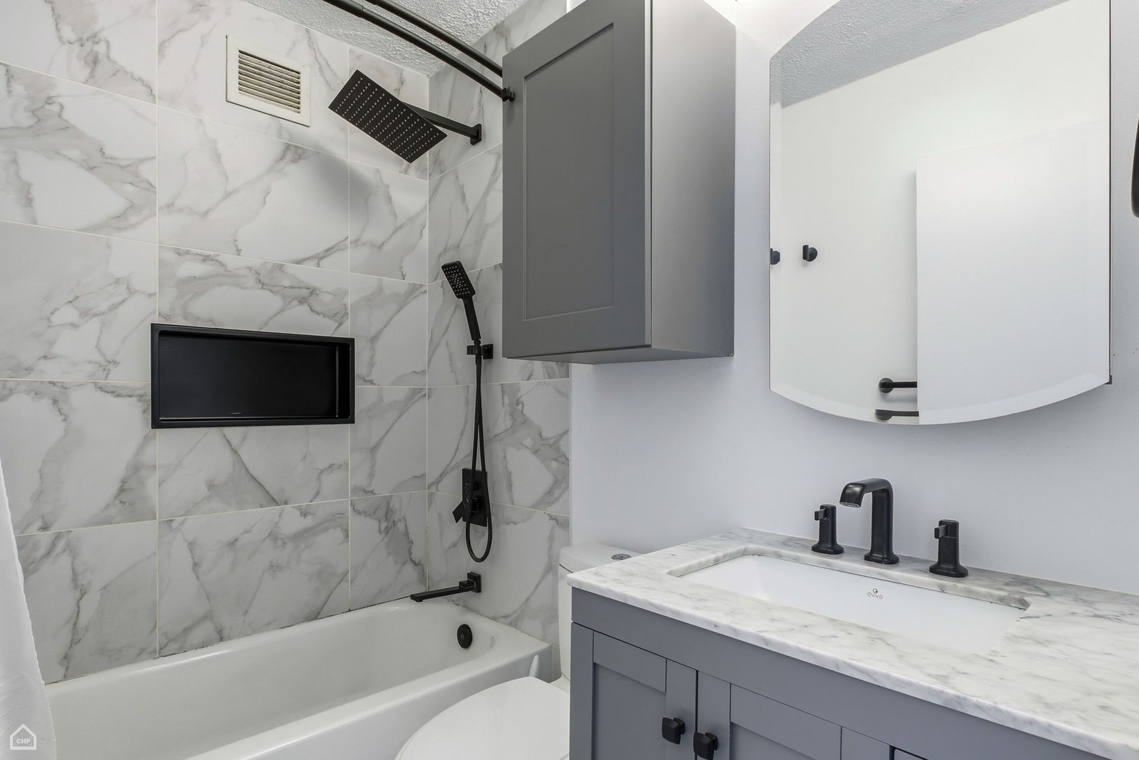 450 West Briar Place, Unit 10H Chicago, IL 60657 - Photo 8 of 17 a bathroom with a granite countertop sink a toilet and bathtub