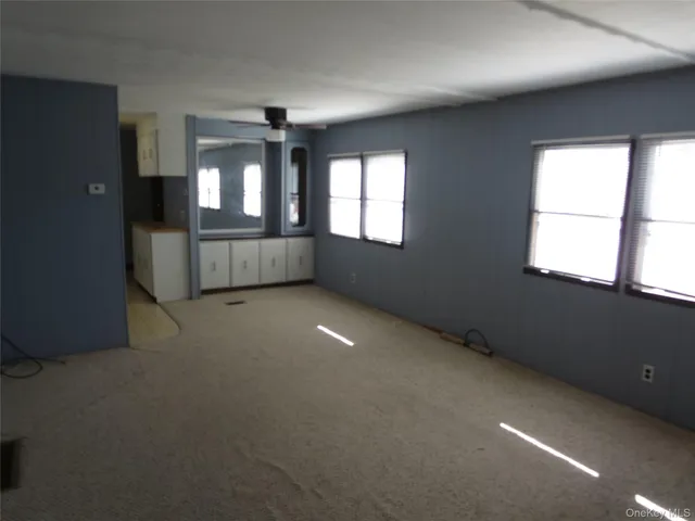 an empty room with windows and cabinet
