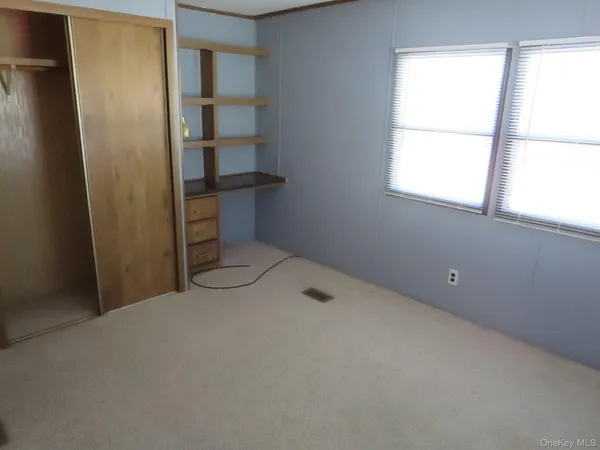 a view of empty room with cabinet and window