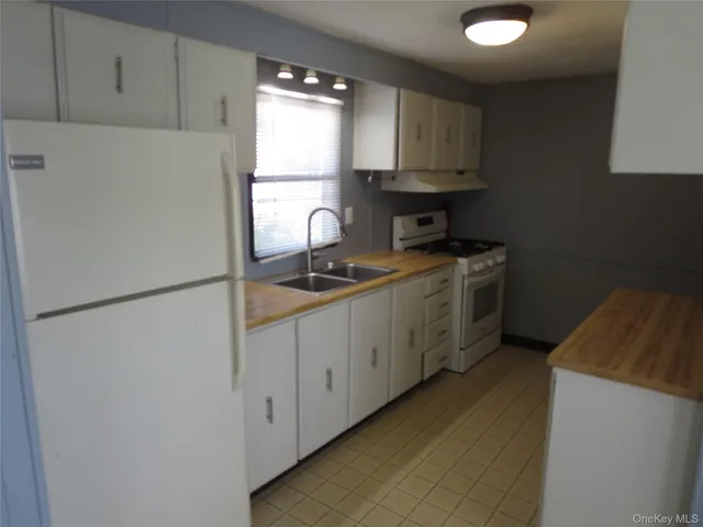 a kitchen with a refrigerator sink stove and cabinets