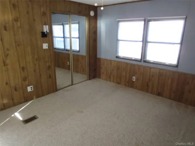 an empty room with windows and closet