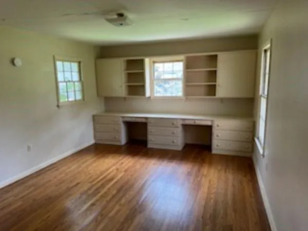 wooden floor in an empty room with a window