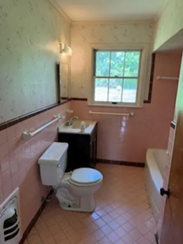 a bathroom with a sink toilet and window