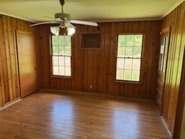 an empty room with wooden floor and windows