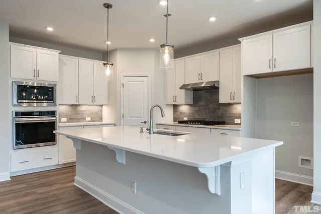 a kitchen with kitchen island a stove a sink and a refrigerator