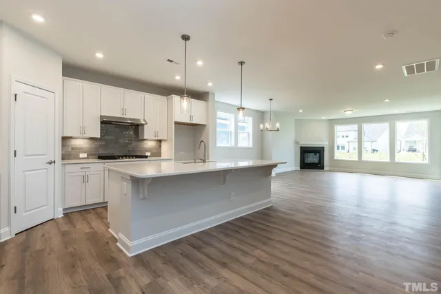 a view of kitchen with granite countertop stainless steel appliances refrigerator sink and cabinets