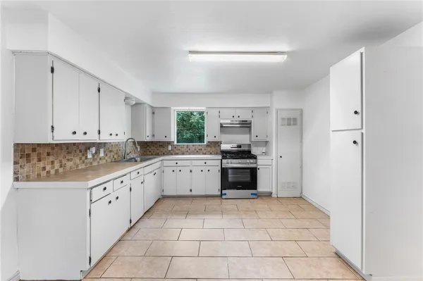 a kitchen with a stove top oven and cabinets