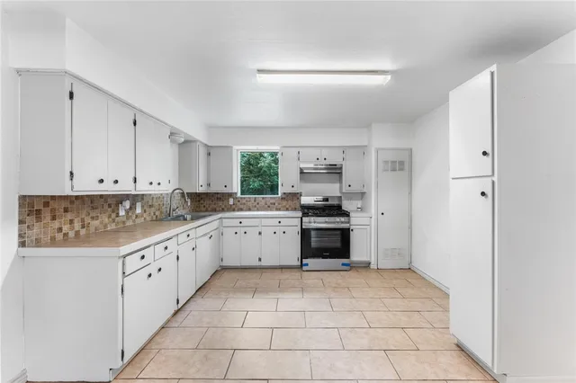 a kitchen with a stove top oven and cabinets