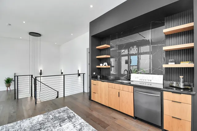 a spacious bedroom with a bed a couch and potted plant with wooden floor