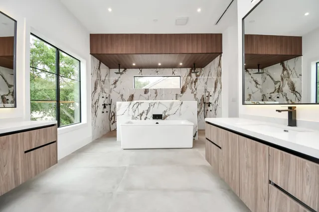 a white bed sitting in a bathroom next to a window