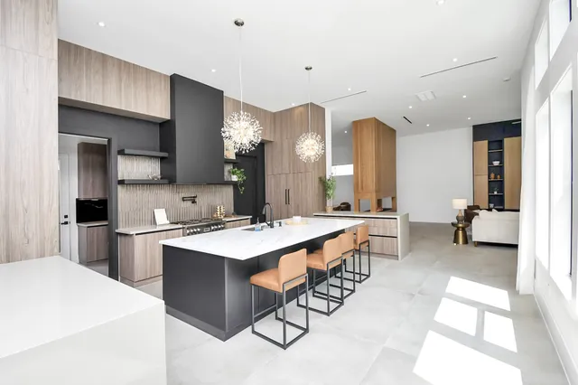 a large white kitchen with a sink and a large window