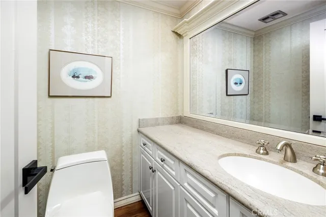 a bathroom with a granite countertop sink a mirror and a toilet