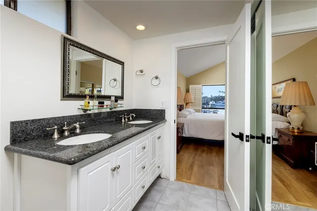 a en suite bathroom with a granite countertop sink and a mirror