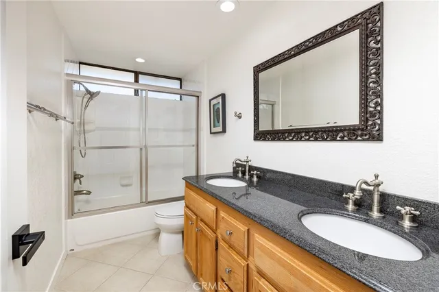 a bathroom with a granite countertop sink mirror toilet and bathtub