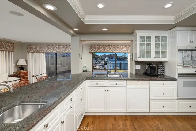 a kitchen with granite countertop a sink and white cabinets