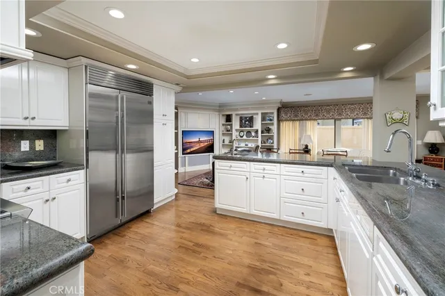 a large kitchen with granite countertop a large counter top stainless steel appliances and cabinets